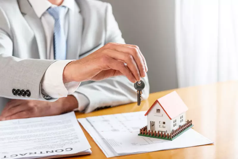 Agen properti memberikan kunci rumah kepada pembeli rumah