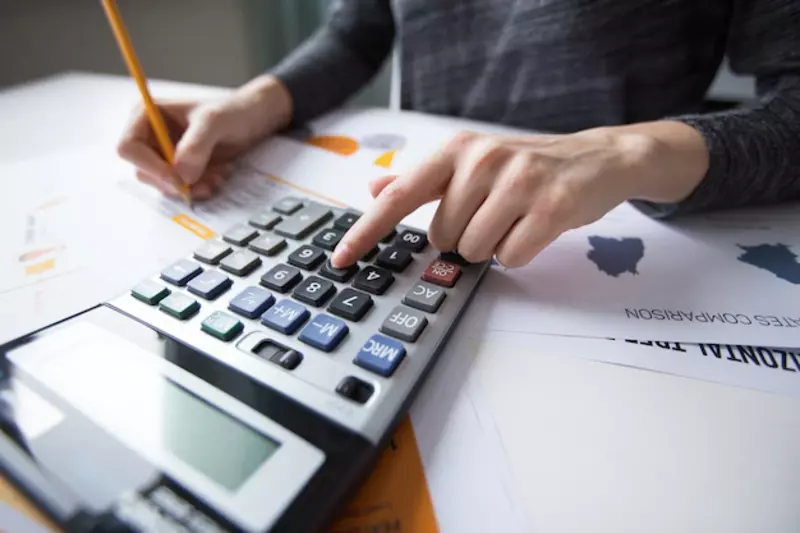 Akuntan menghitung keuangan bisnis menggunakan kalkulator